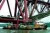 MarineCos tug MarineCo Akela and a barge are seen working on the refurbishment of Scotlands Forth rail Bridge this summer.