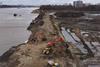 Construction vehicles breaching a dyke at the Scheldt river in Antwerp