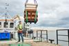 The image shows one of the clay bricks designed to house juvenile oysters being lowered into the water