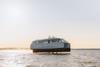 The image shows the Candela P-12 electric ferry on the water