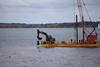 A bucket grab crane mounted on Mistley Marine's flat top barge Spartacus salvages the rocket remains.