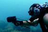 A diver with hand-held tracking device is directed towards the EMT pinger.