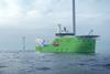 A Bibby Marine offshore service vessel on the water with wind turbines in the background