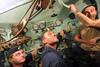 Russian submariners listen as a NATO rescue vehicle connects with a Russian submarine for the first time ever.