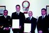 Commodore Amjad Hussain presents bravery awards to UMC diving supervisors Dave Thatcher and James Jee, with UMC director Peter Stevenson in attendance.