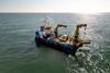 The image shows Jan De Nul's Voe Vanguard Multicat vessel at sea during the project