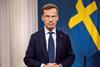 The image shows the ​the Swedish Prime Minister, Ulf Kristersson, pictured in front of a Swedish flag