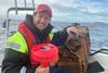 The image shows John Olav Florø-Larsen on board his vessel with the SmartOcean wave indicator