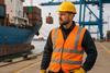 The image shows a AI generated image of a dockworker on the quayside with a ship in the banckground