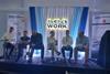 The image shows the speakers seated on stage