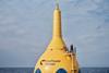 A giant CorPower Ocean yellow buoy with a man standing on top