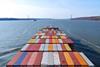 Image shows the view from the front of a container ship at sea with the deck full of cargo