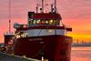 An image of the Fugro Enterprise survey vessel at dock at sunset