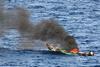 Suspected pirate skiff burns after attack. Photo: US Navy/JRZalasky