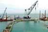A 200 ton crane barge places caissons for the award winning breakwater.