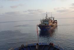 Fishing vessel being towed at sea