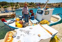 Fisherman stood on the deck of his small fishing boat in the eastern Aegean Sea