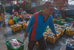 The image shows an Indonesian fisher on board a vessel