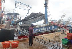 The image shows a Thai fishing vessel on the quayside