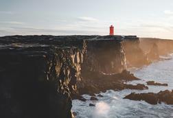 A red lighthouse on a cliff