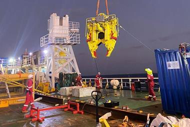 Decom Engineering's C1-24 Chopsaw in action. The saw is suspended above a ship's deck with workers