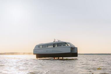 The image shows the Candela P-12 electric ferry on the water
