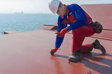 The image shows a worker testing the efficacy of Hempel marine coatings