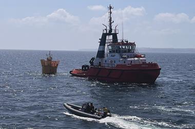 The image shows a MMS workboat on the water