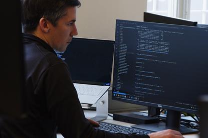 The image shows a male user accessing AI modelled data on a computer screen