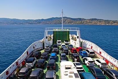 Cars on board a RoRo ferry at sea with land in the background