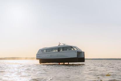 The image shows the Candela P-12 electric ferry on the water