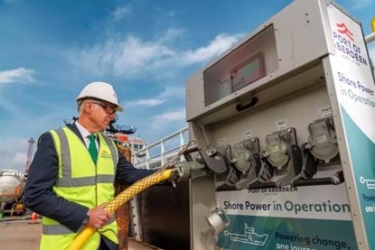 The image shows an high-vis engineer in front of the shore power facilities at Aberdeen