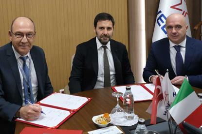 The image shows parties from the three companies signing the MoU