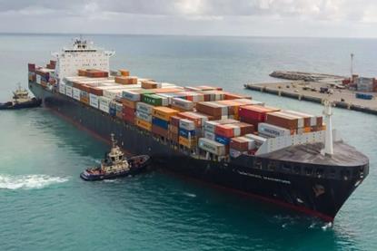 The image shows Svitzer tugs guiding a container ship into port