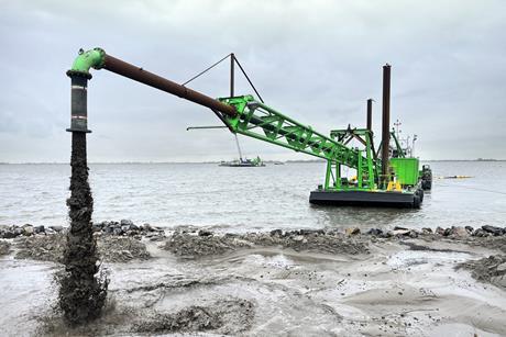 DEME dredger at work reinforcing the dyke at Marken