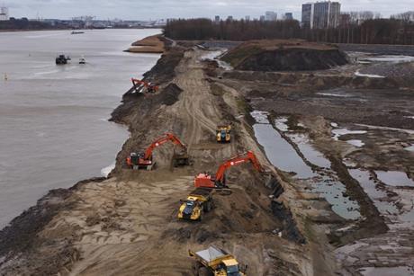 Construction vehicles breaching a dyke at the Scheldt river in Antwerp