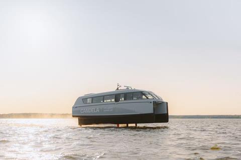 The image shows the Candela P-12 electric ferry on the water